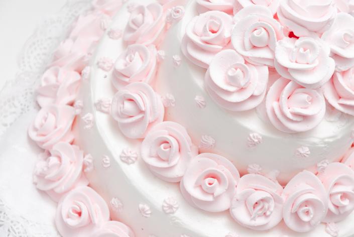 The pink frosting roses against the satin white icing makes this a perfect wedding cake for traditional receptions.
