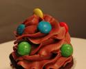 A delicious chocolate cupcake topped with chocolate icing and M&M's.
