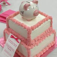 Simple, yet classic for this new little girl. Fluffy tuffs of pink icing line the edges, while a cute little piggy bank keepsake adorns the top. 