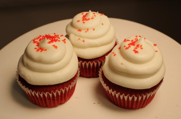 Amazingly delicious red velvet cupcakes topped with cream cheese icing and red sprinkles.